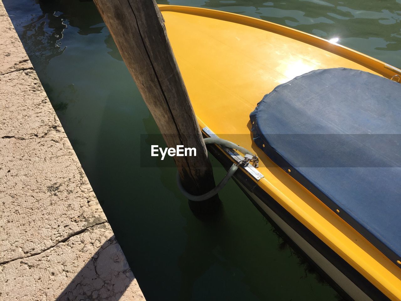 HIGH ANGLE VIEW OF YELLOW BOAT MOORED AT LAKE