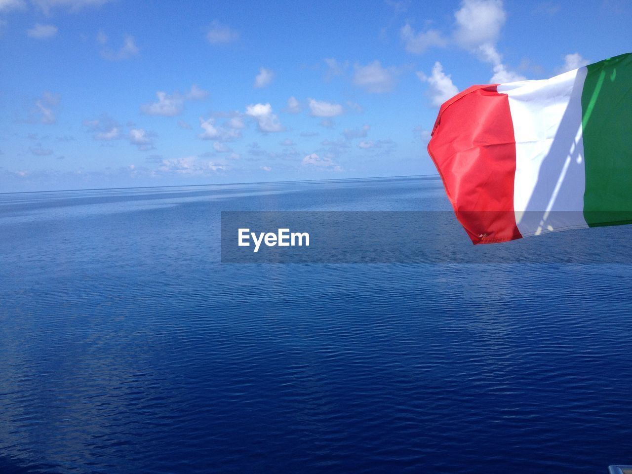 Italian flag waving against sea