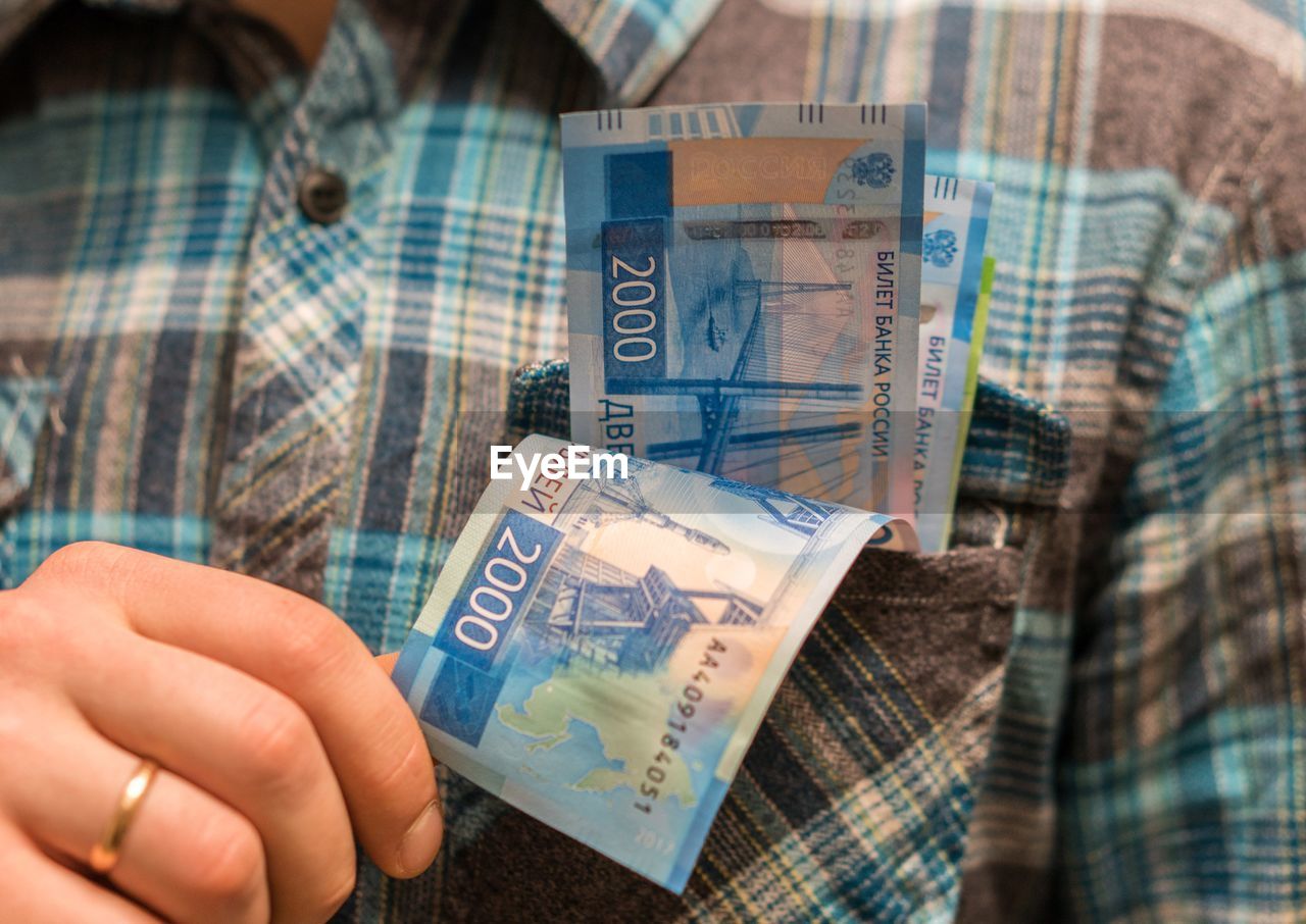 Midsection of man with money in pocket