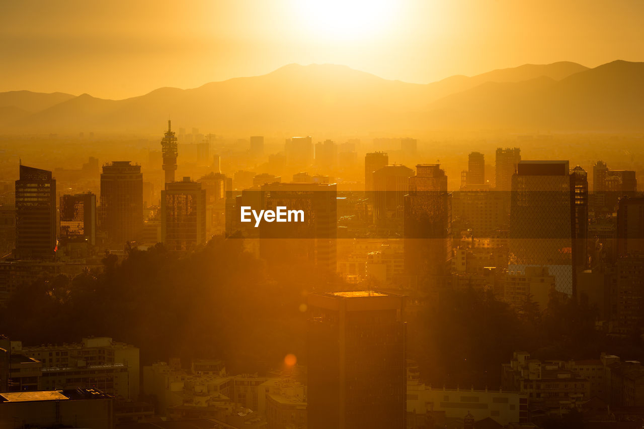 Aerial view of buildings in city during sunset