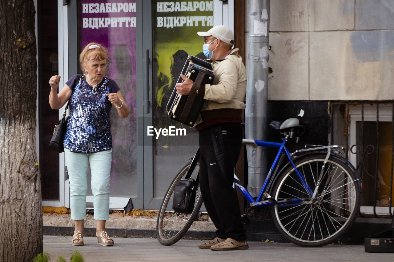 WOMEN STANDING BY BICYCLE