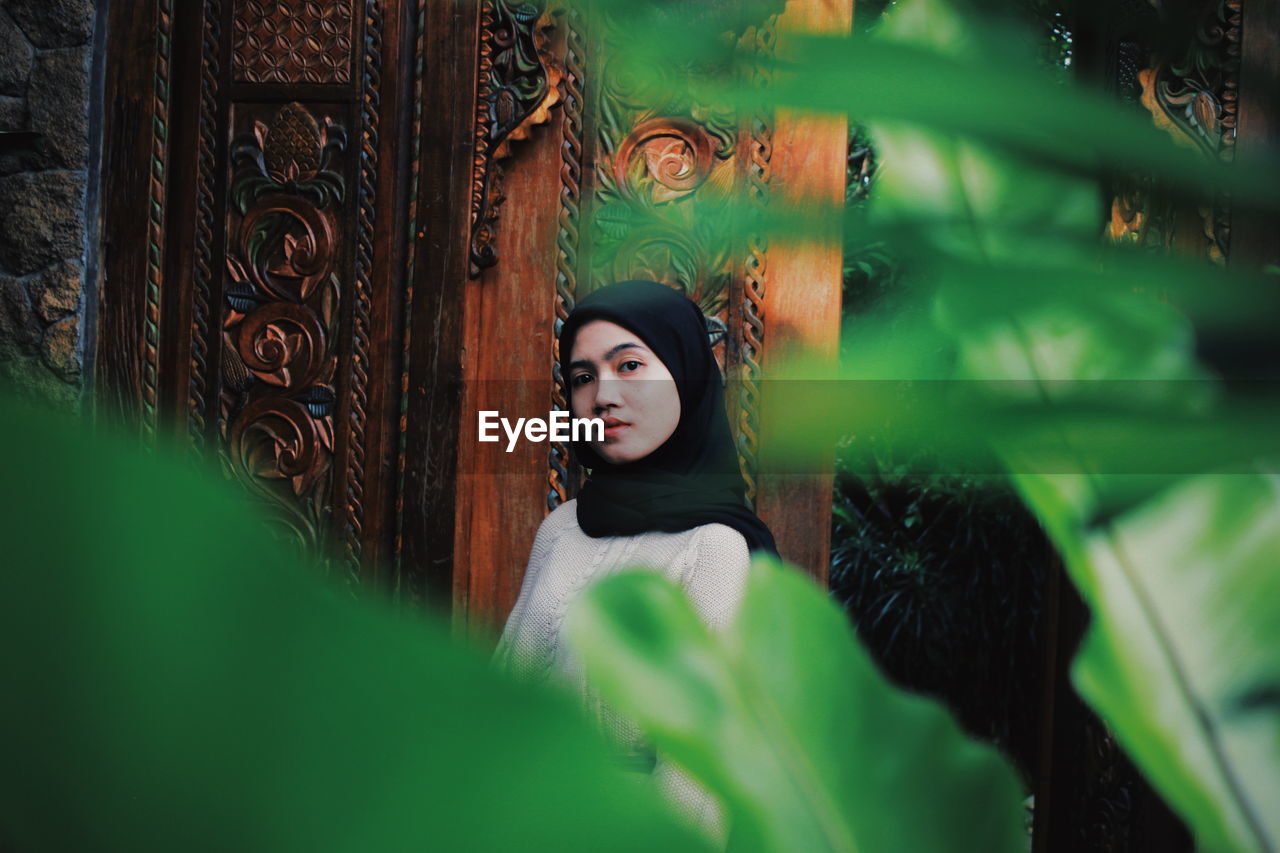 Portrait of woman against plants