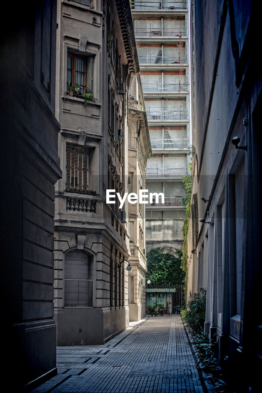 Empty alley amidst buildings in city