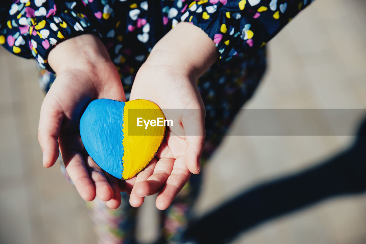 Small little kid hold heart with ukraine flag. child stand for ukrainians. stop war, agression