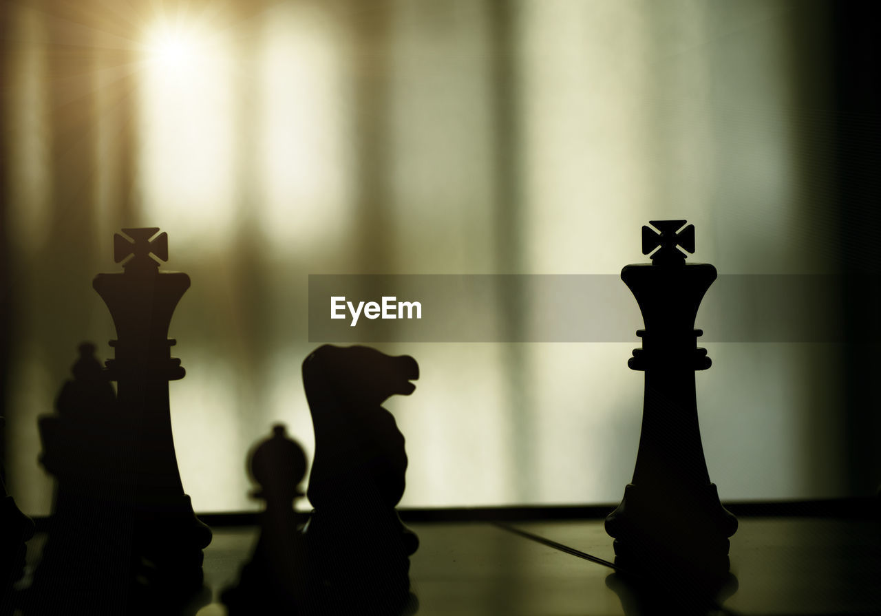 Silhouette of chess pieces on white background. silhouette of black king are leader to fight .