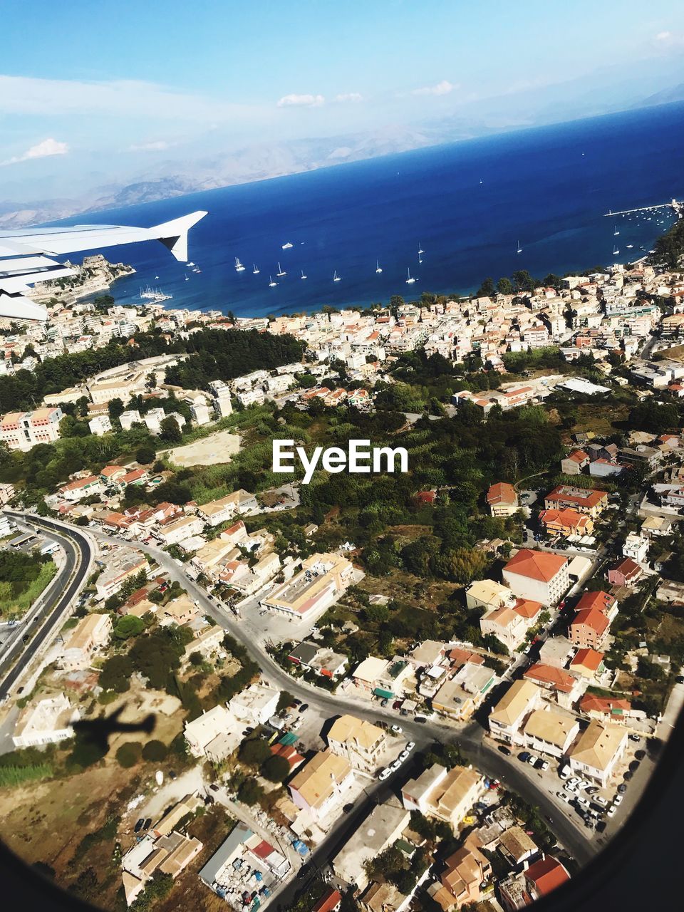 AERIAL VIEW OF TOWNSCAPE AND SEA AGAINST SKY