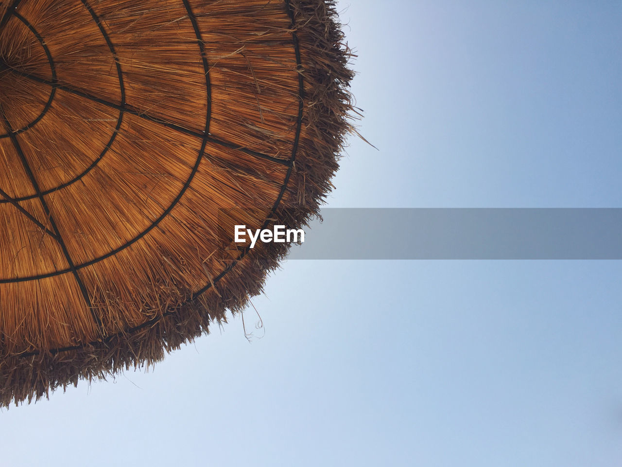 Low angle view of under a parasol against clear sky