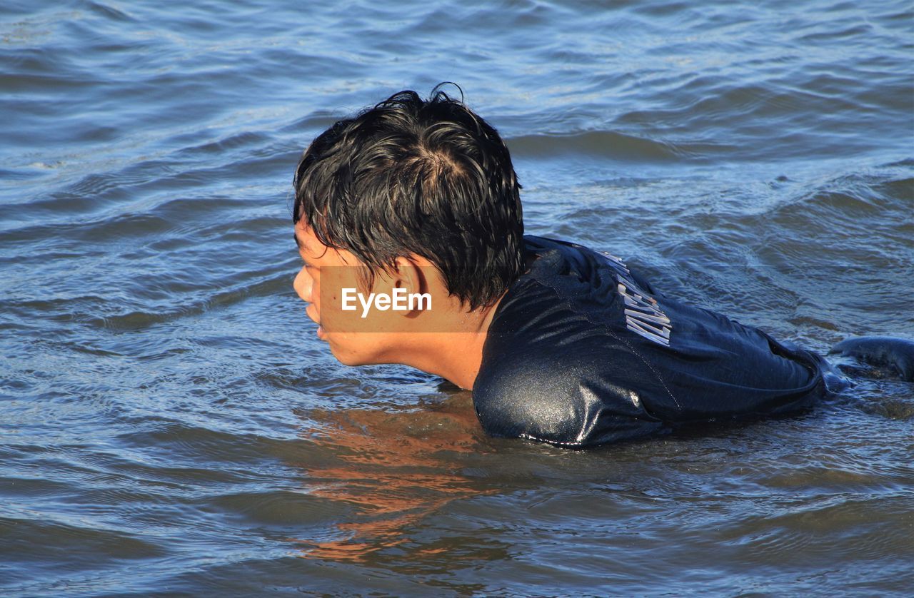 PORTRAIT OF BOY IN WATER AT SEA