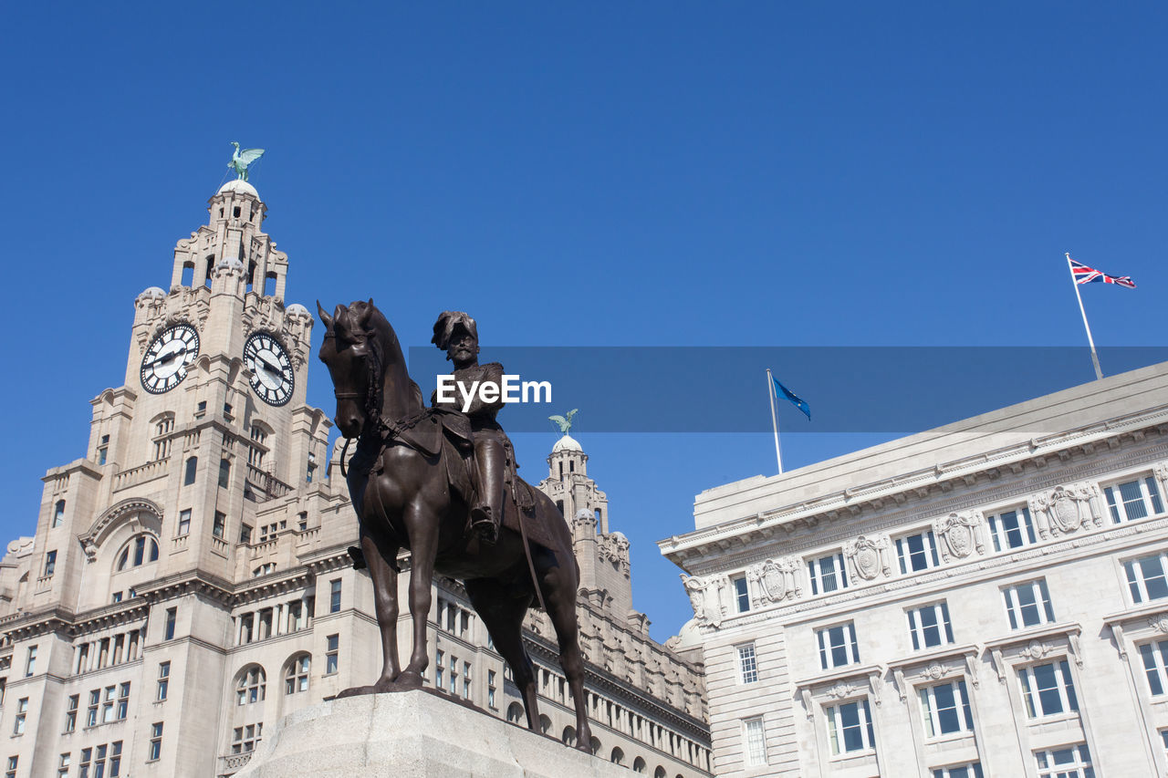 Low angle view of clock tower against blue sky