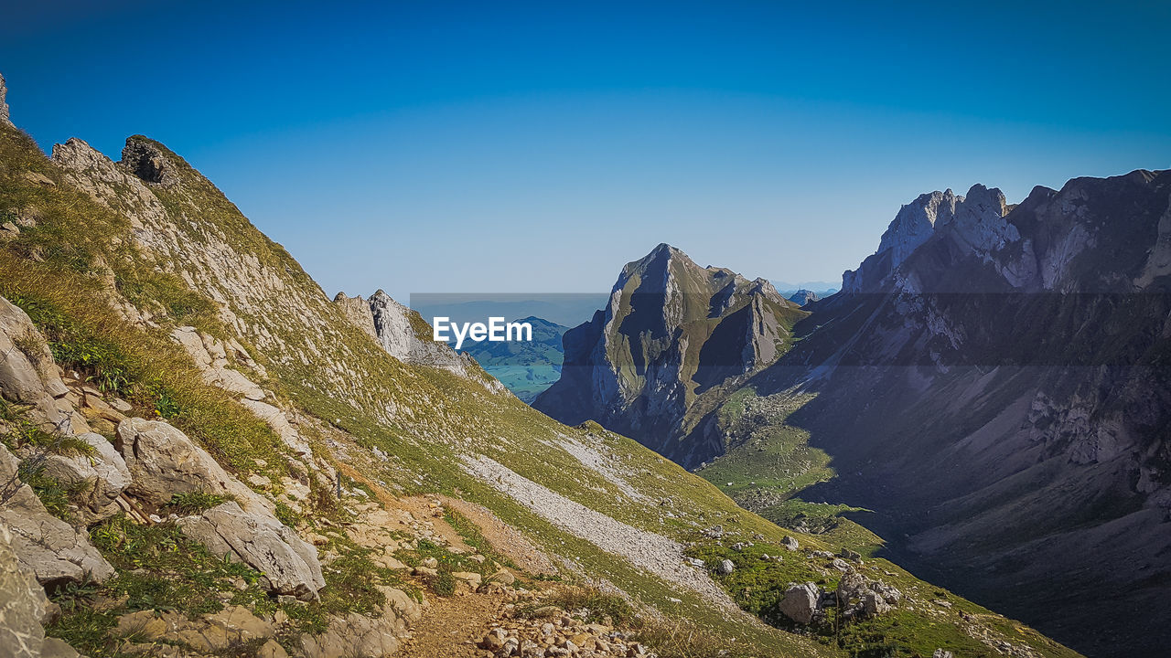 Scenic view of mountains against clear blue sky