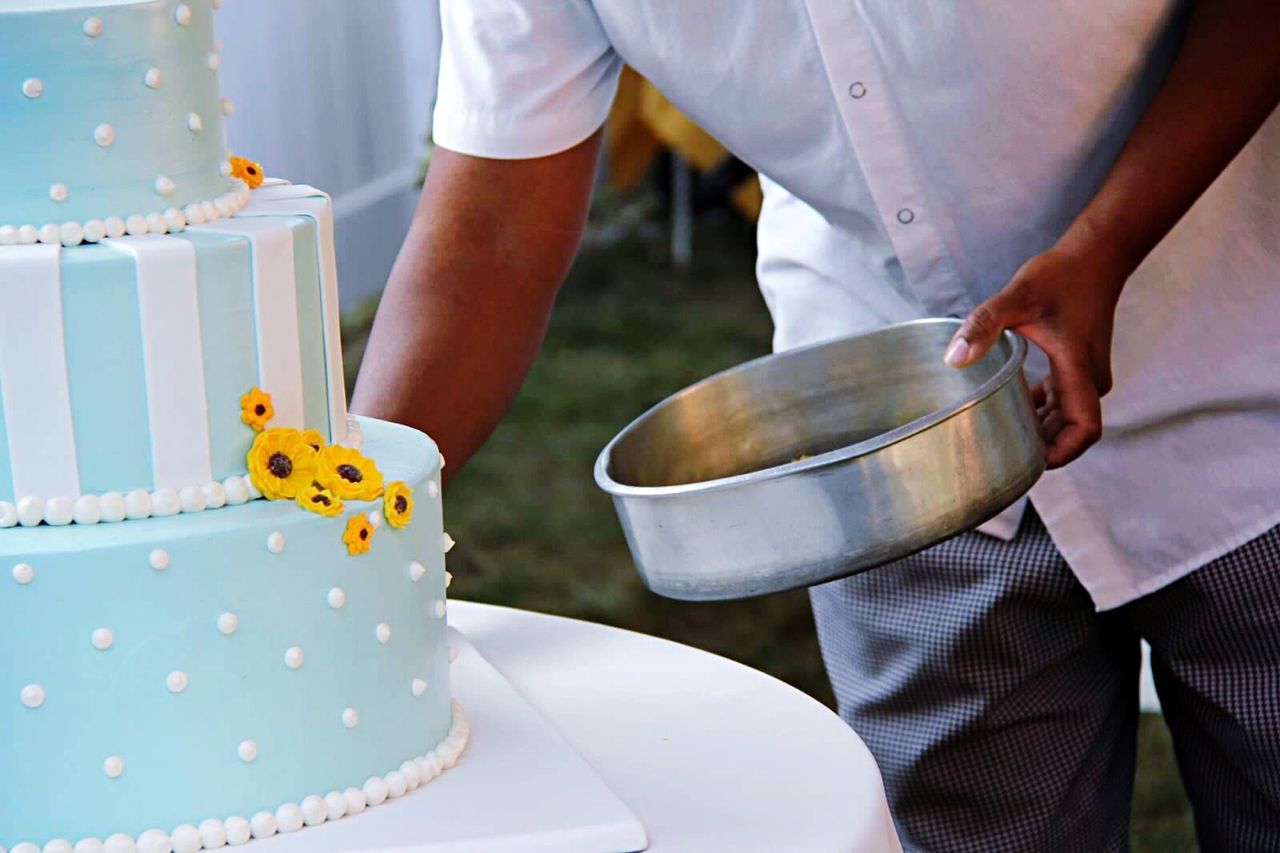 Midsection of man holding container by cake