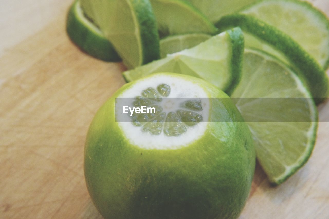 HIGH ANGLE VIEW OF GREEN FRUITS ON TABLE