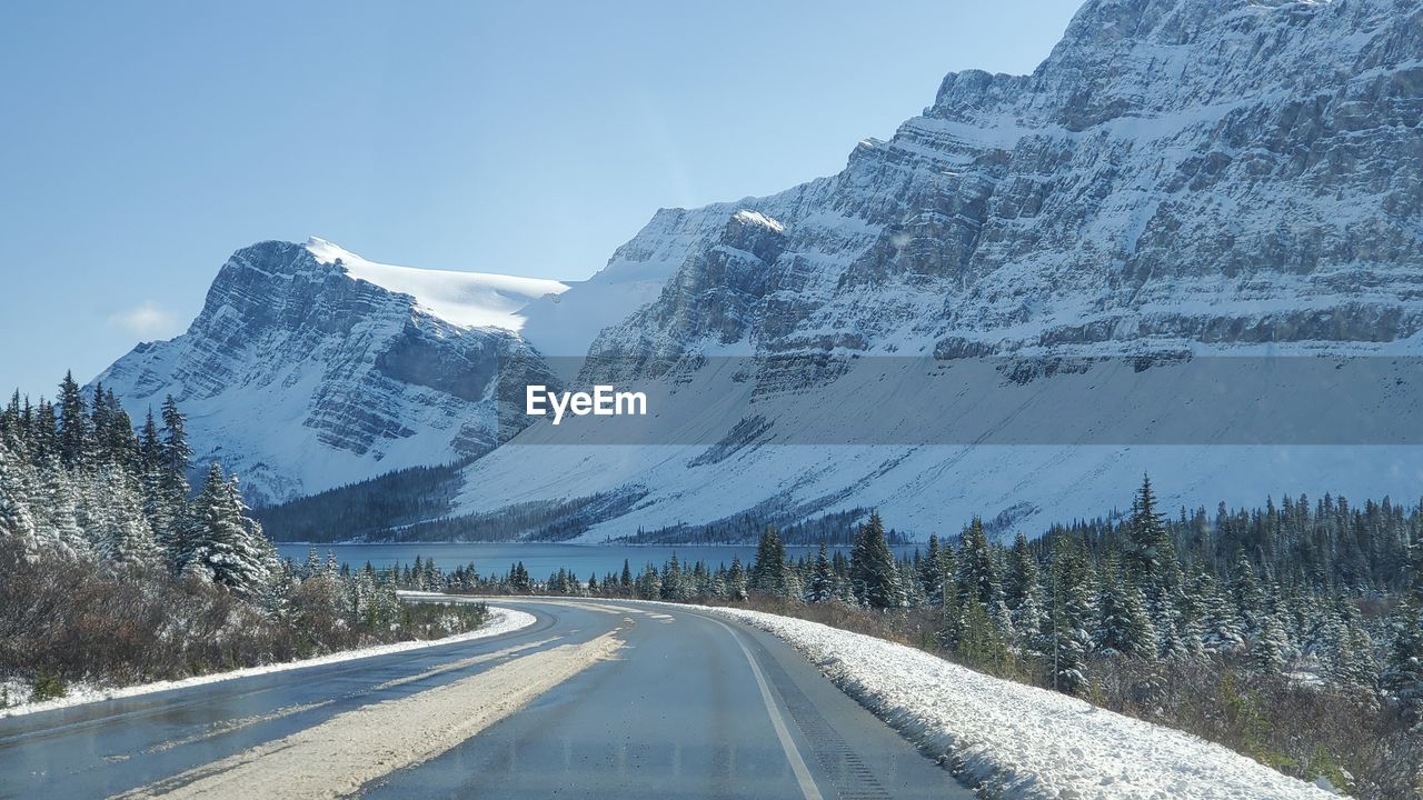 Road amidst snowcapped mountains against sky