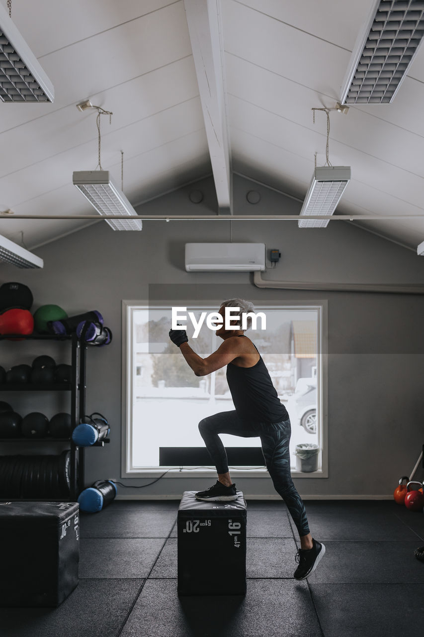 Side view of mature woman training in gym