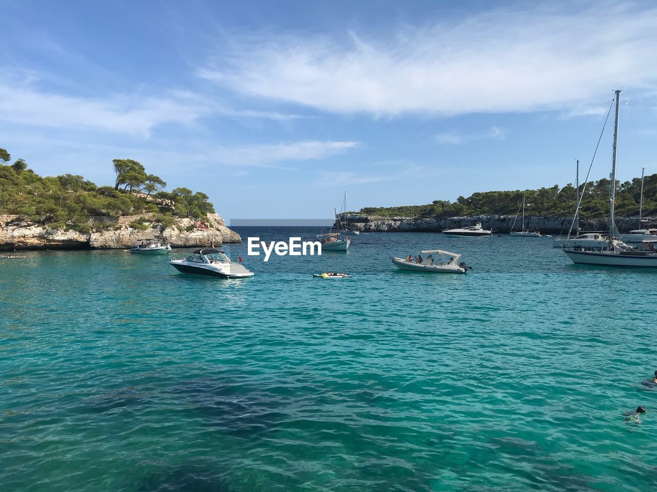 Sailboats moored on sea against sky