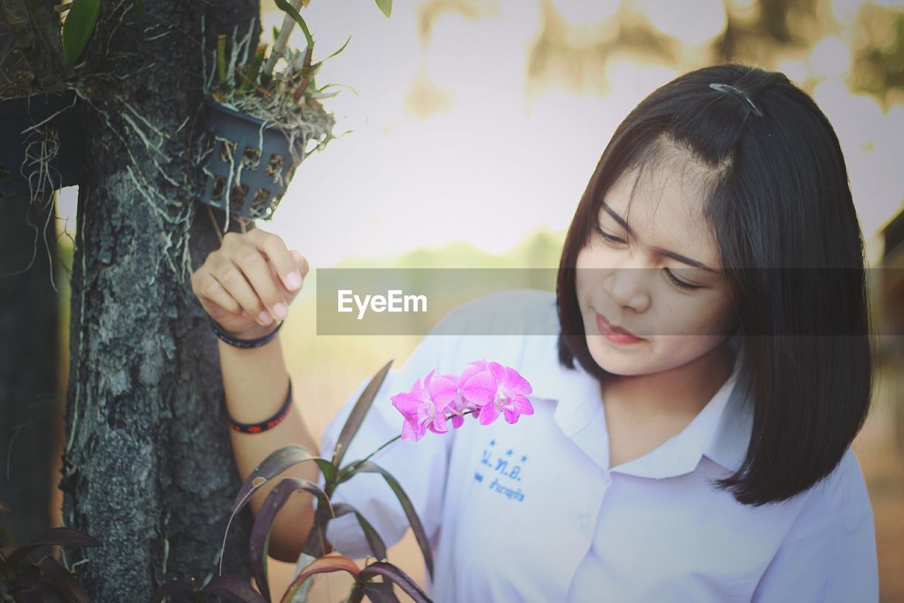 CLOSE-UP OF GIRL LOOKING AWAY AGAINST TREES