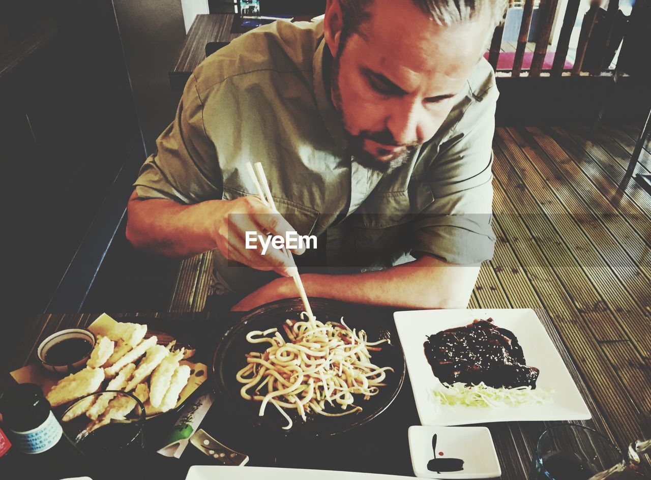 MIDSECTION OF MAN HOLDING FOOD