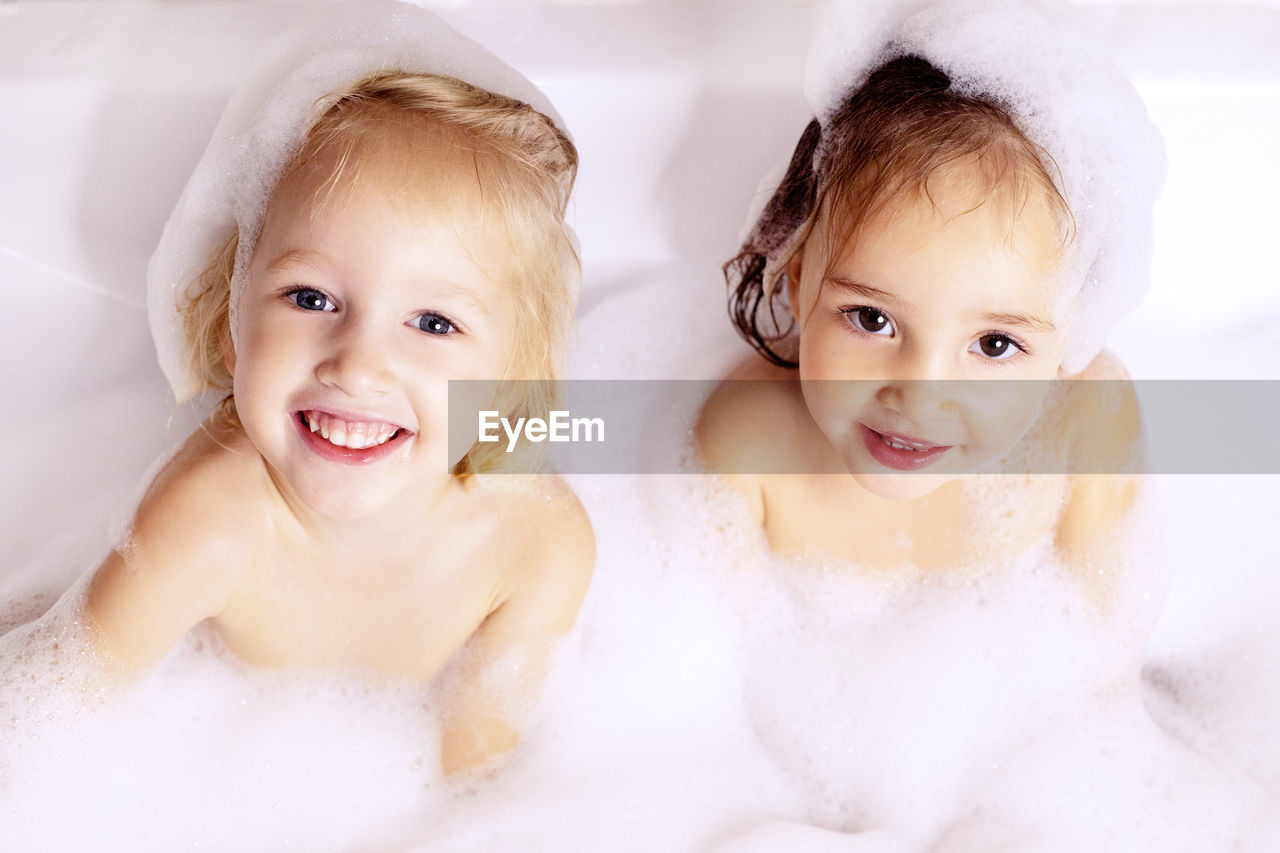 Portrait of cute girls bathing in bathtub