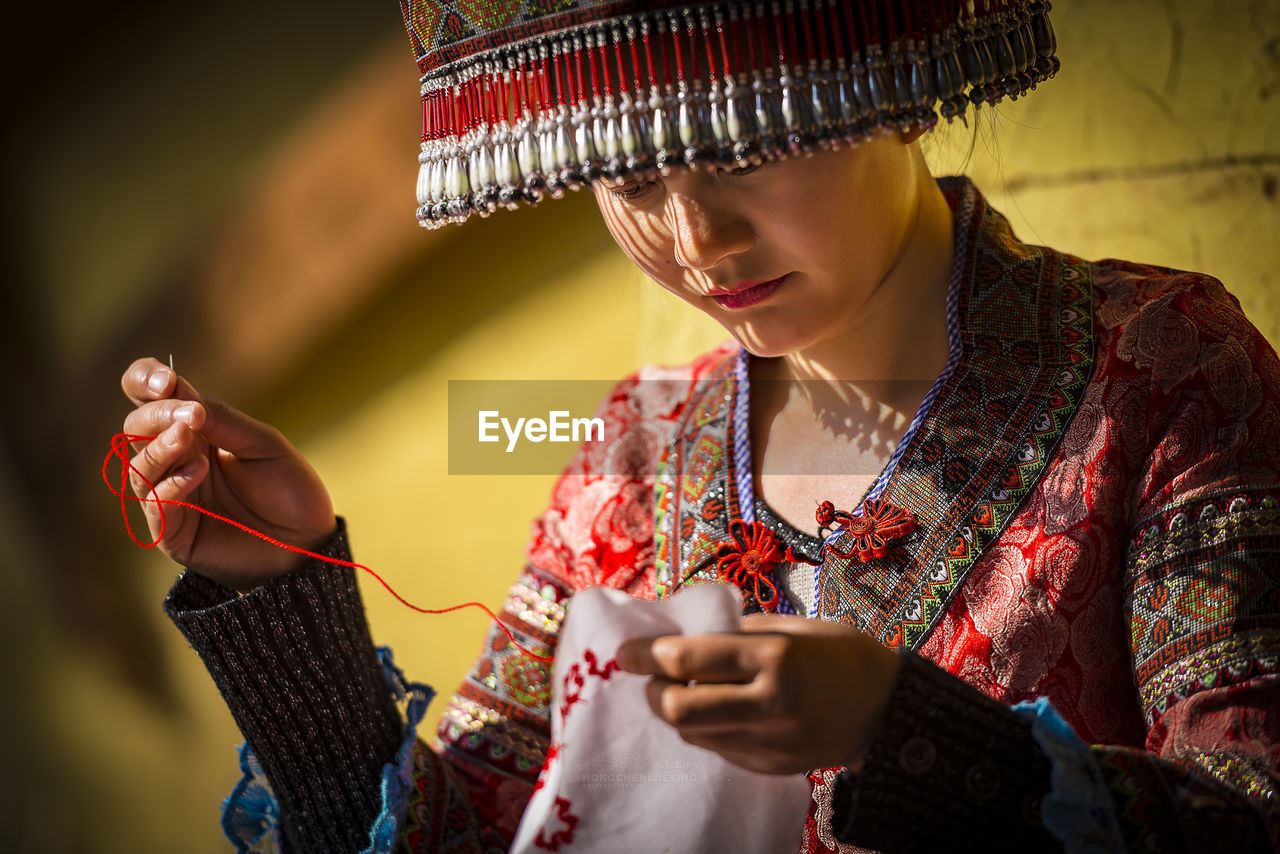 Young woman knitting on cloth