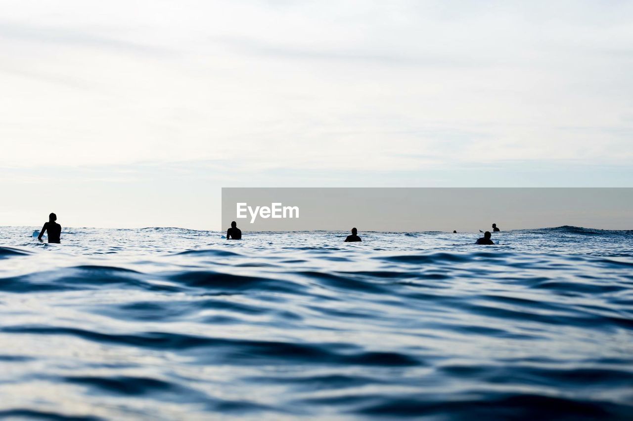 Silhouette of men surfing in sea