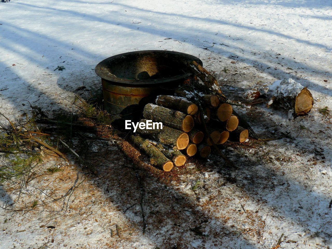 High angle view of firewood and container on snow