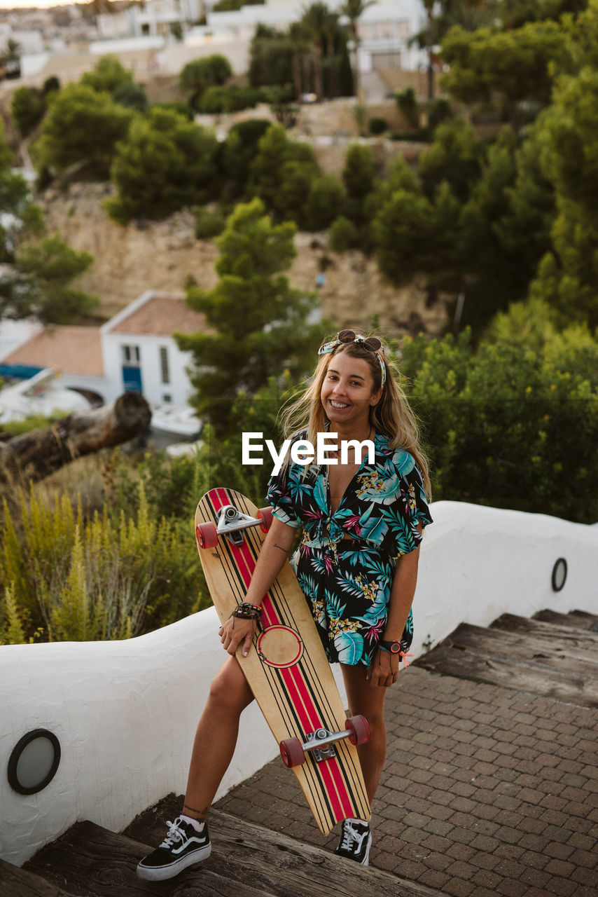 Young happy female with long board skate in moraira
