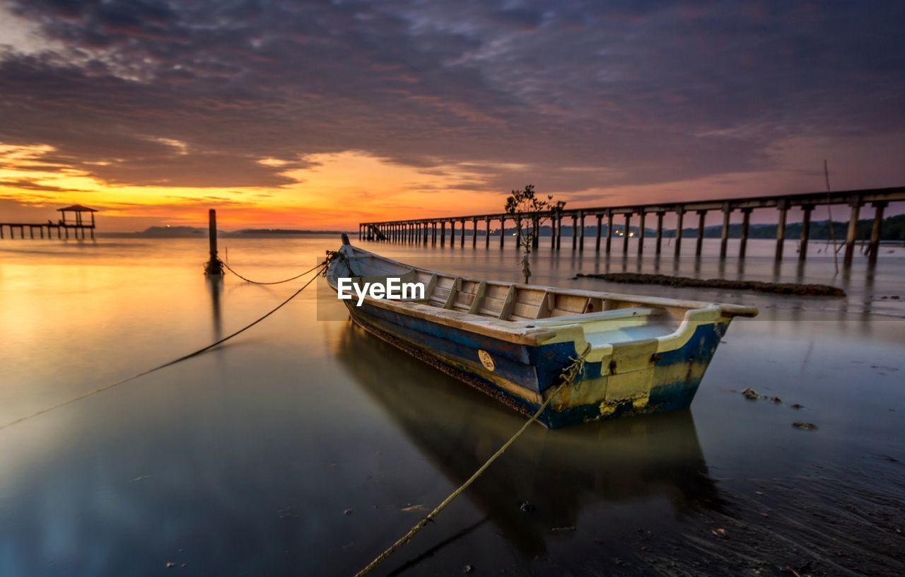 BOAT MOORED ON SEA AGAINST SKY