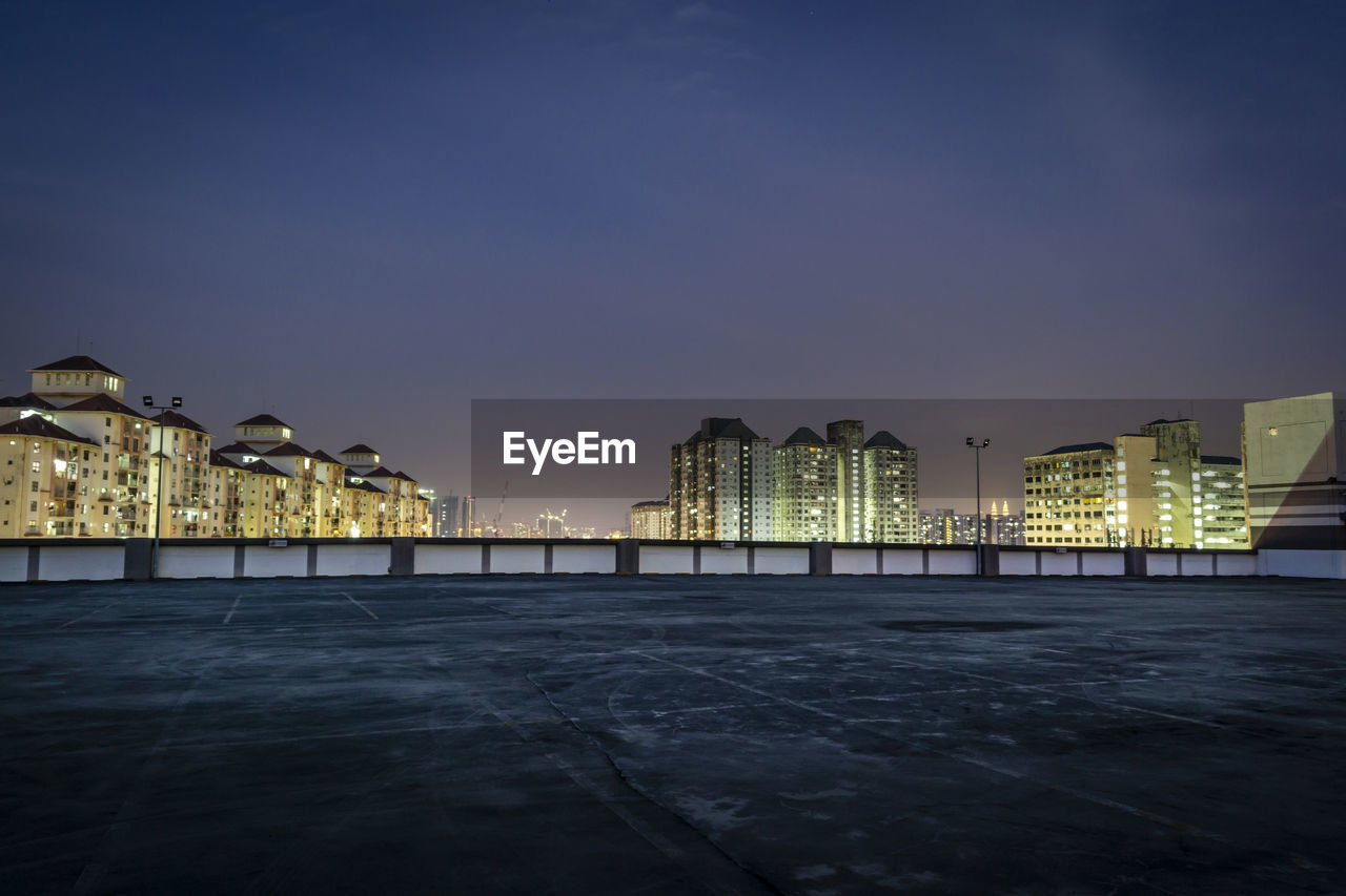 ILLUMINATED CITY BUILDINGS AGAINST SKY AT NIGHT