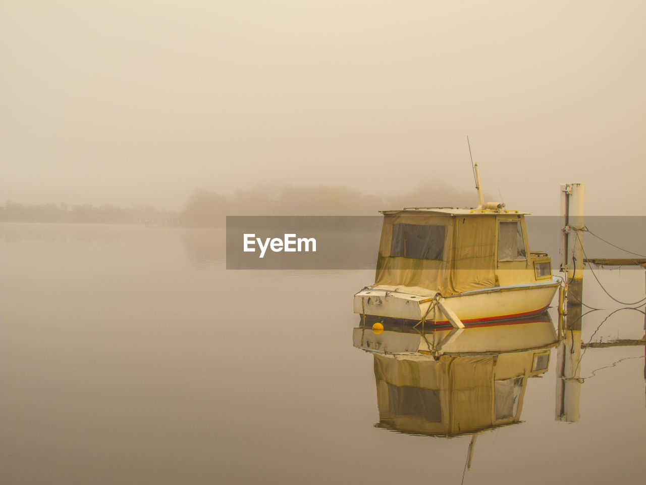 Boat moored on lake against sky