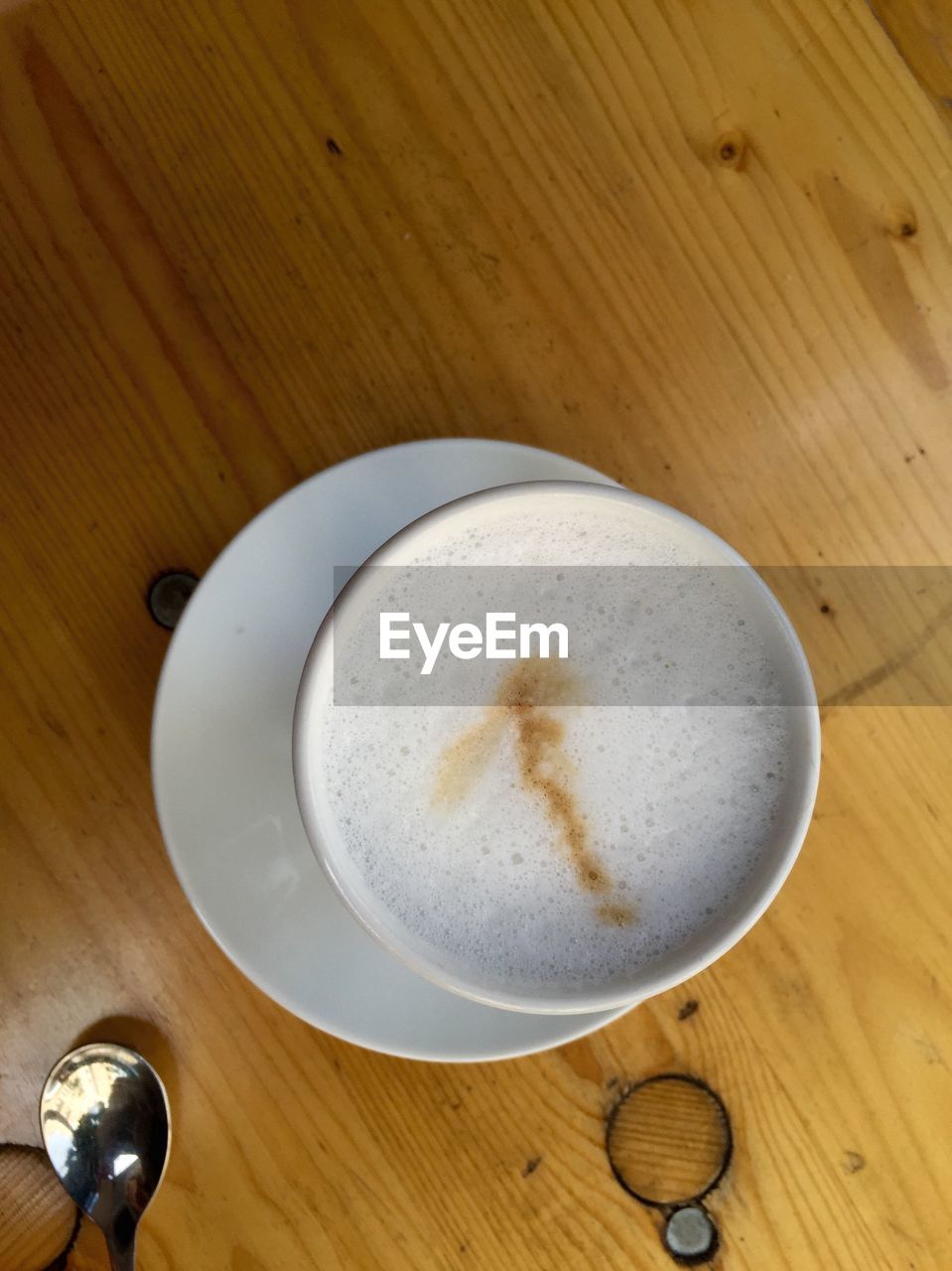 High angle view of coffee cup on wooden table