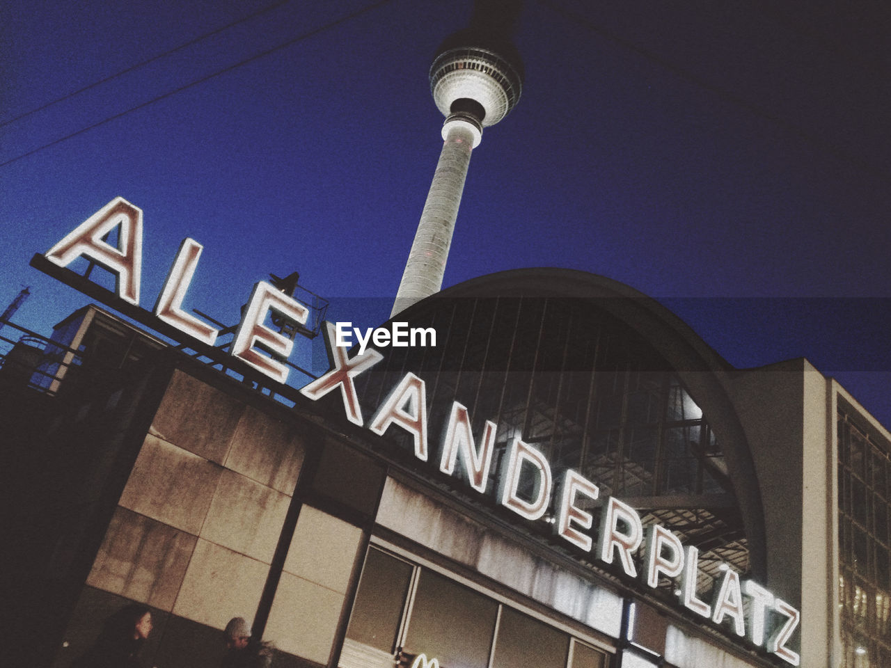 Low angle view of alexanderplatz by fernsehturm against sky at night