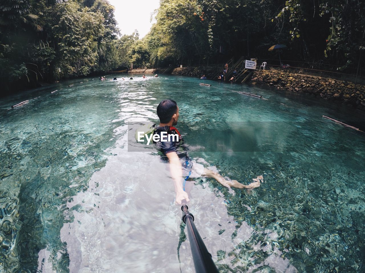 Man holding monopod in lake