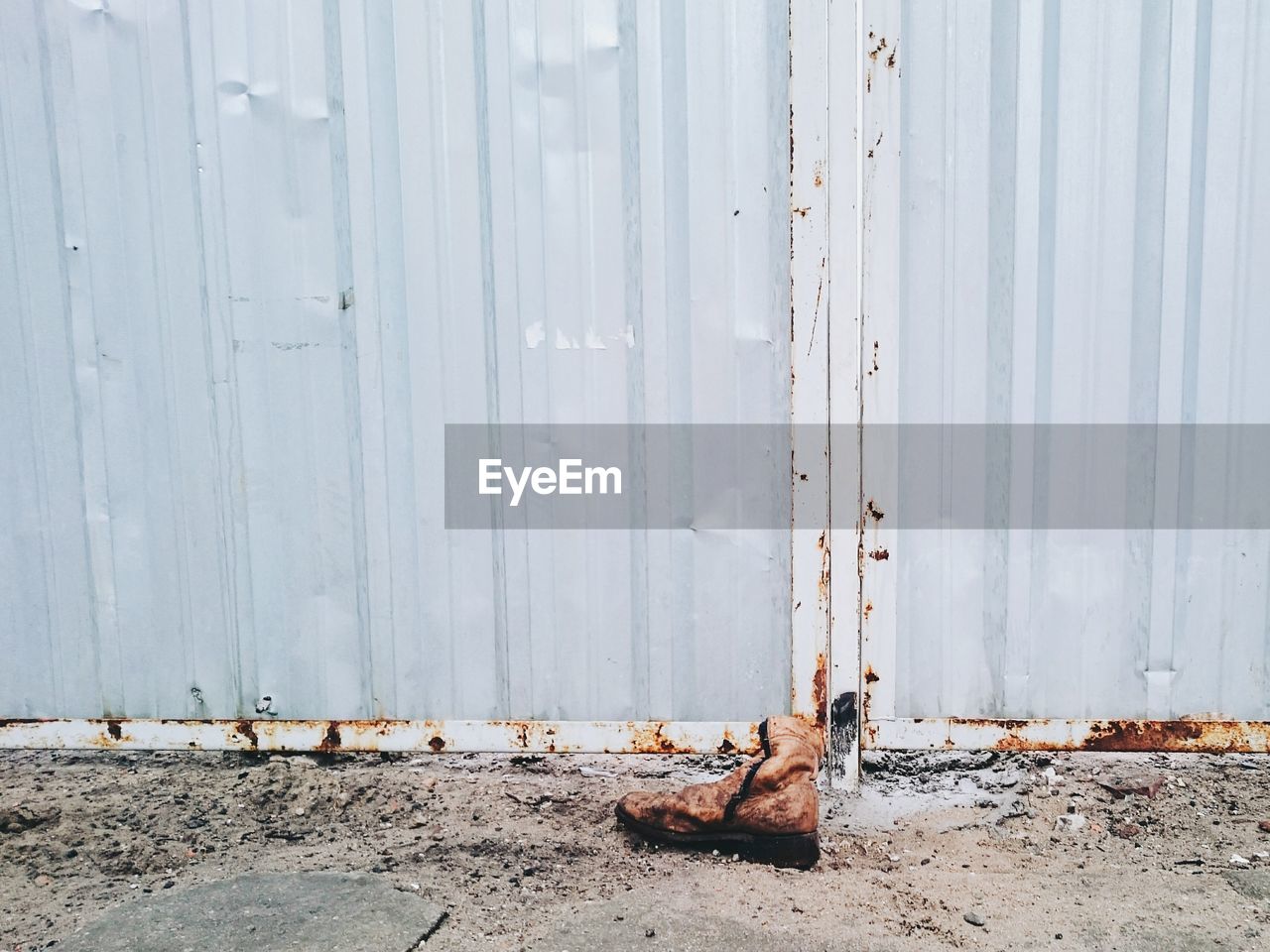 Abandoned boot in front of aluminum wall