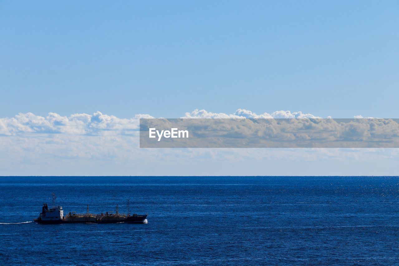 BOAT IN SEA AGAINST SKY