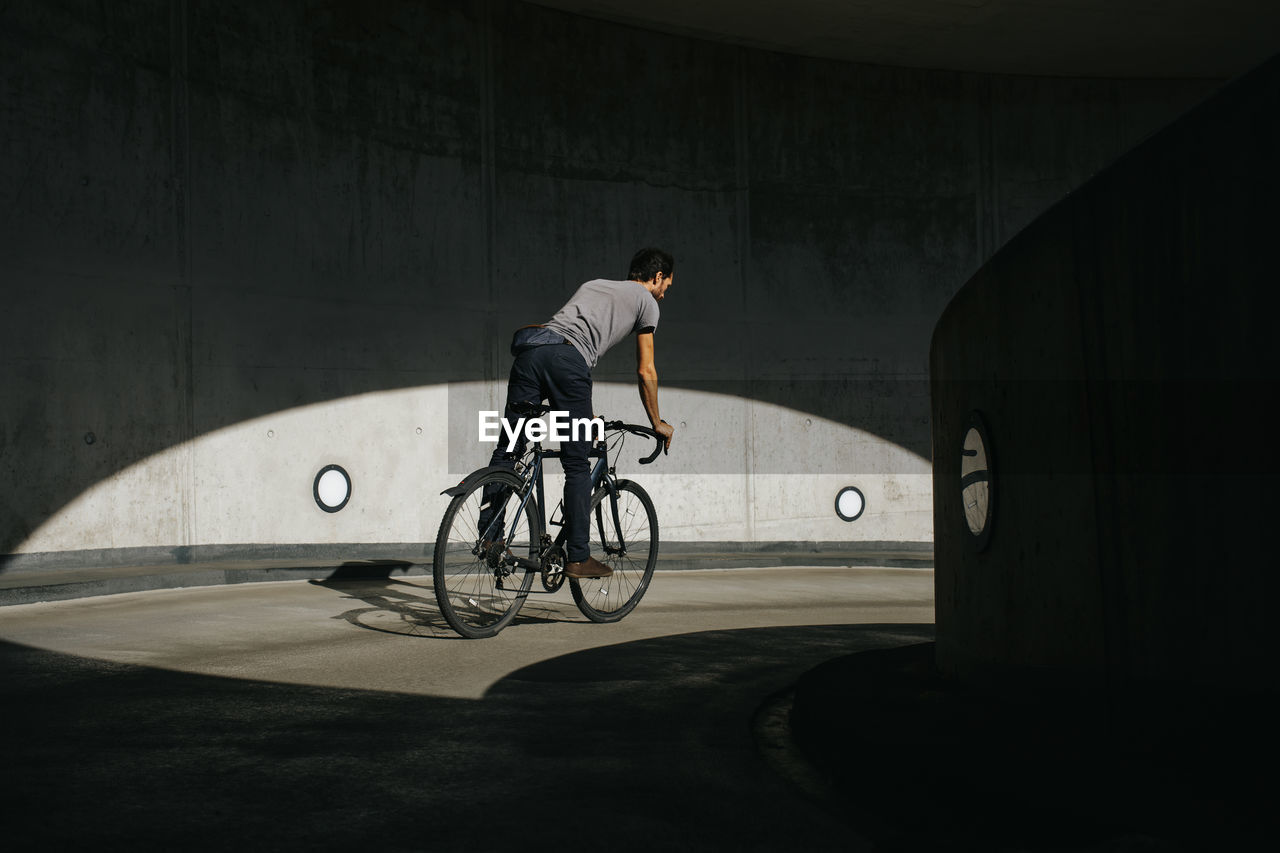 MAN RIDING BICYCLE IN STREET