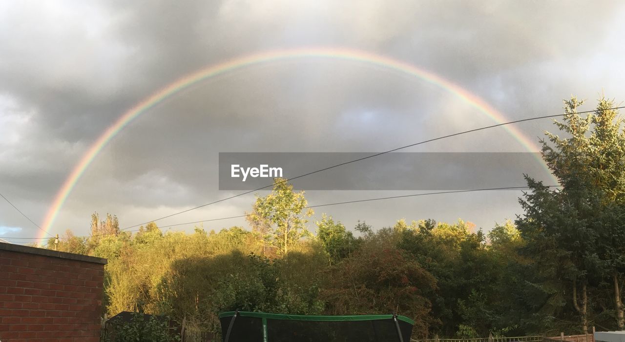 LOW ANGLE VIEW OF RAINBOW OVER TOWN