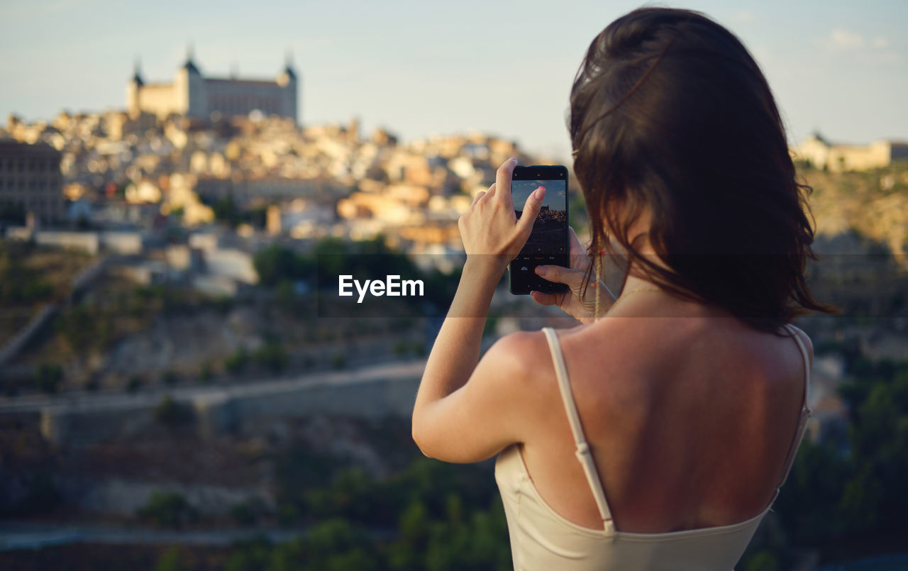 side view of young woman photographing through camera