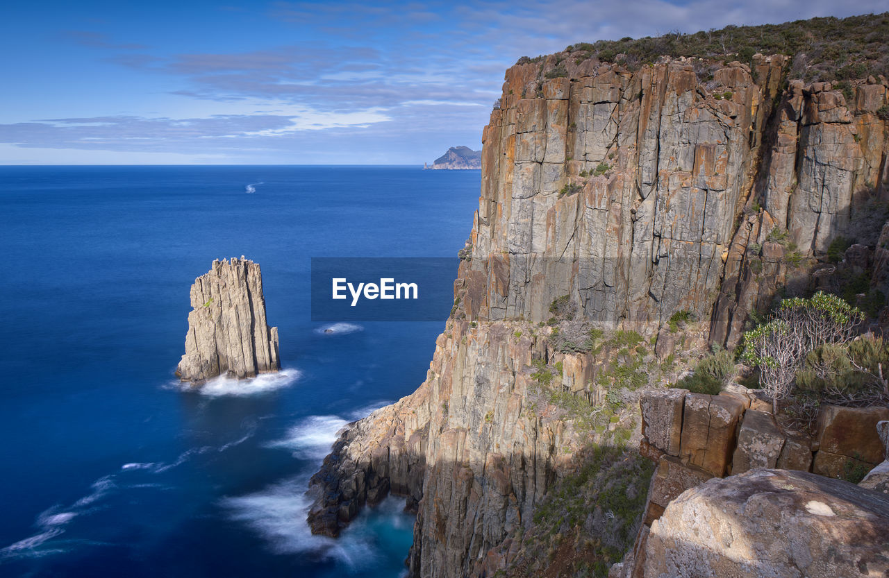 Rock stack beside dolerite sea cliffs on cape huay hiking trail, tasmania, australia