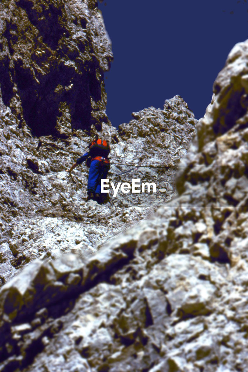 LOW ANGLE VIEW OF PERSON ON SNOWCAPPED MOUNTAIN