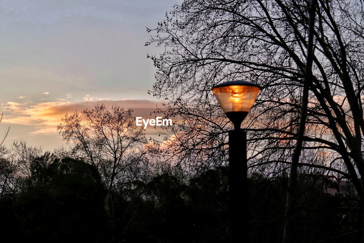 LOW ANGLE VIEW OF STREET LIGHT AT SUNSET