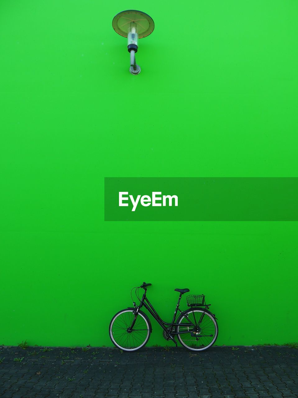 Bicycle against green wall