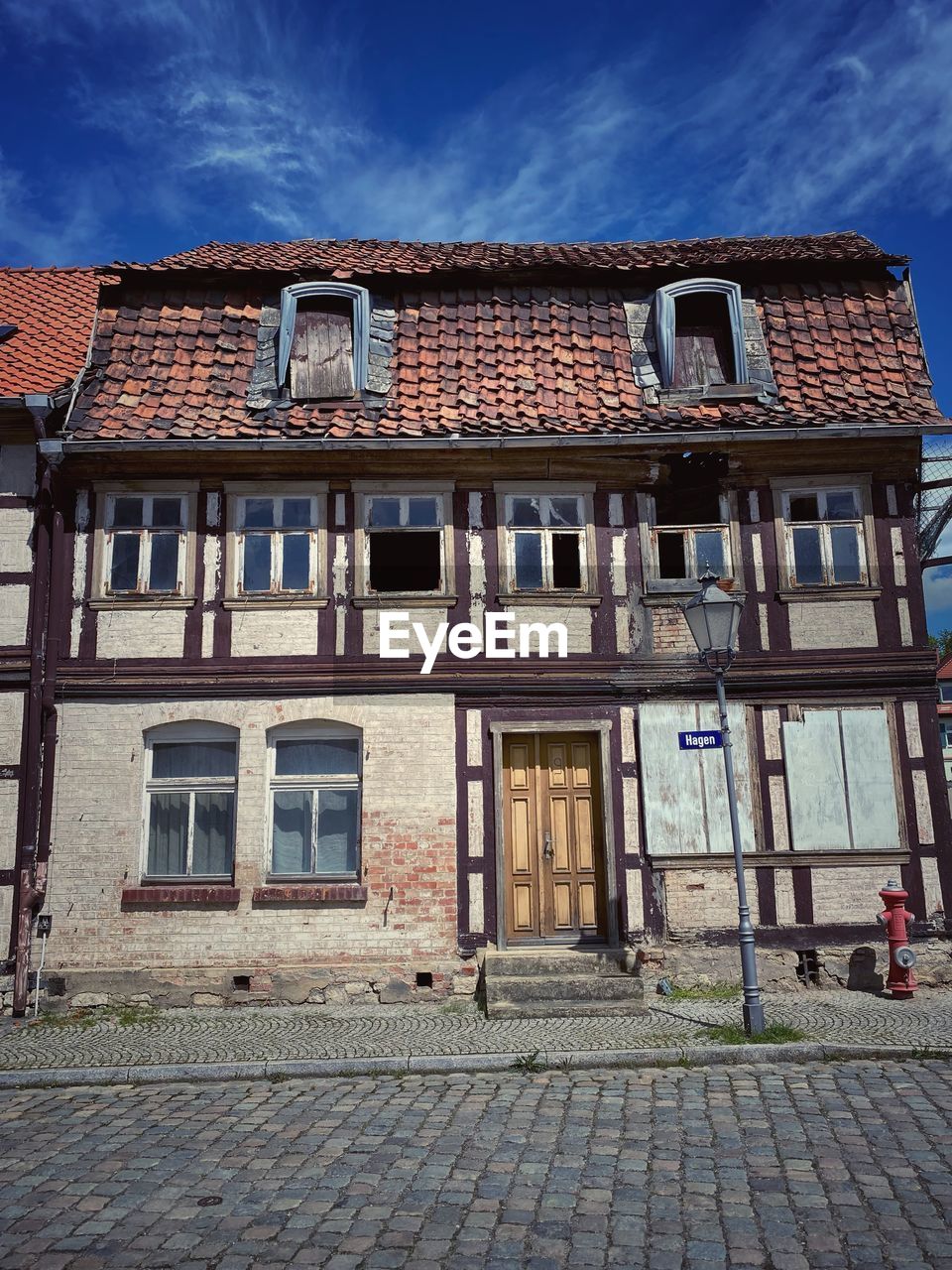 LOW ANGLE VIEW OF BUILDING BY STREET AGAINST SKY