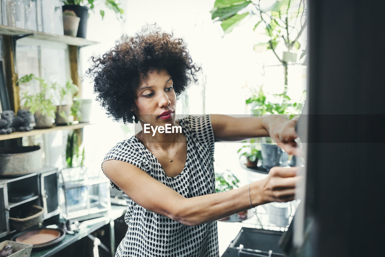 Mid adult woman working in interior design shop