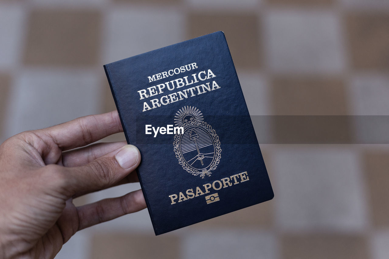 Close-up of human hand holding passport