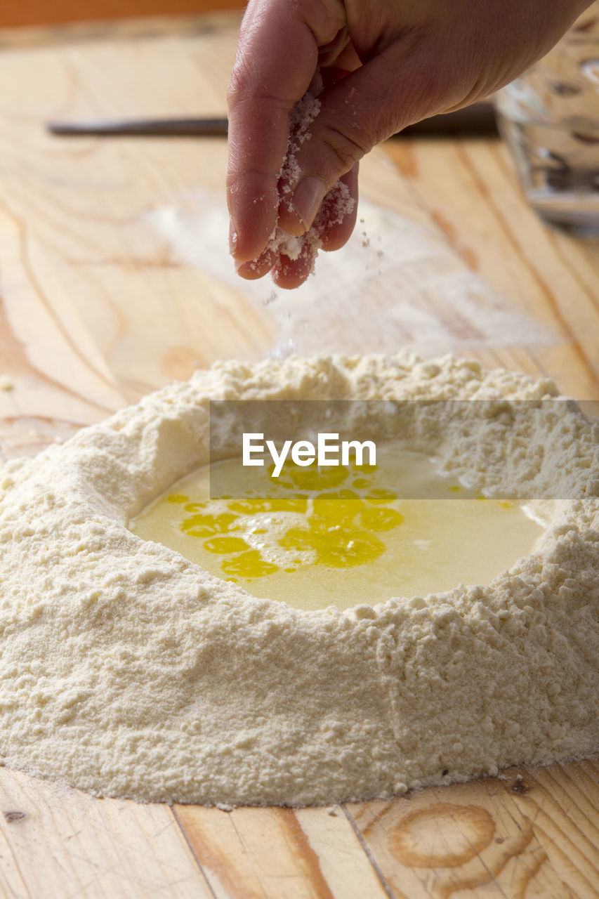 Cropped image of hand preparing ravioli dough on table