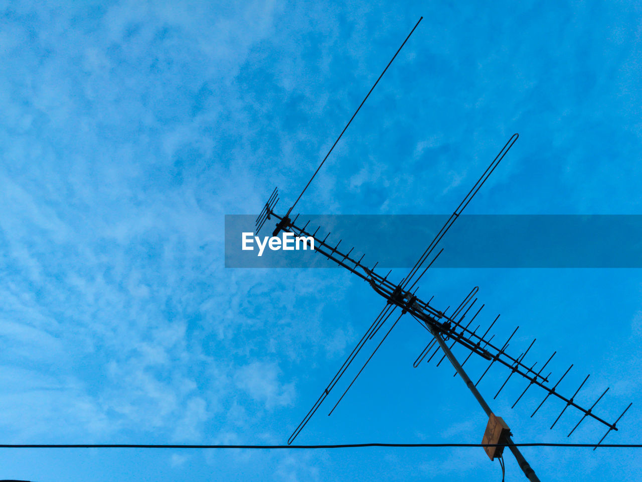 Low angle view of power line against blue sky