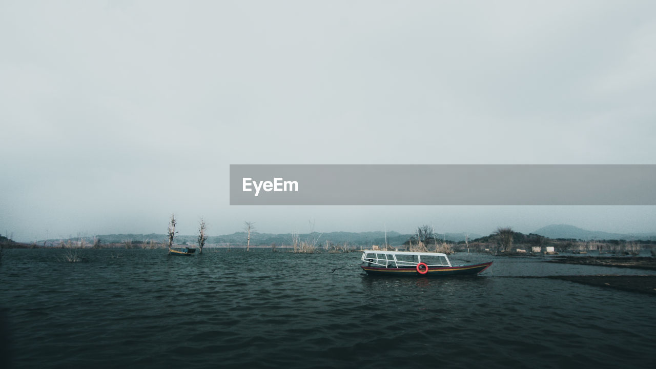 BOATS SAILING IN SEA AGAINST SKY