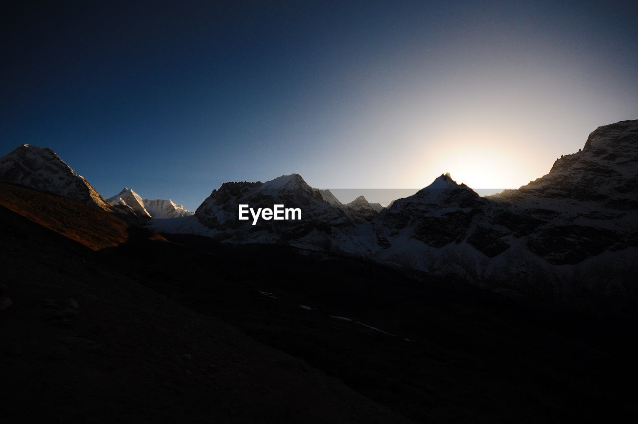 Scenic view of snowcapped mountains against clear sky during winter