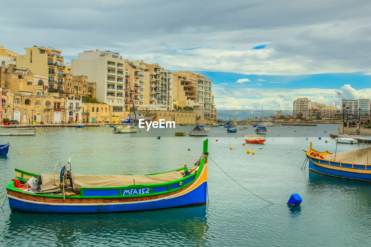 Boats in harbor with buildings in background