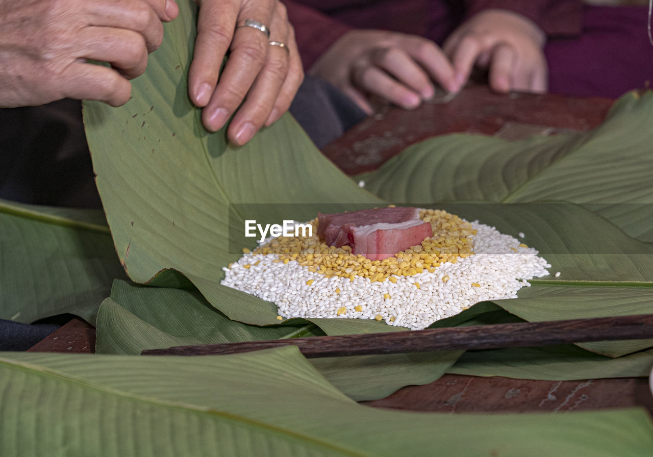 hand, food and drink, food, adult, birthday cake, men, two people, flower, women, freshness, leaf, plant part, indian food, senior adult, sweet food, indoors, banana leaf, lifestyles, togetherness, holding, rice - food staple